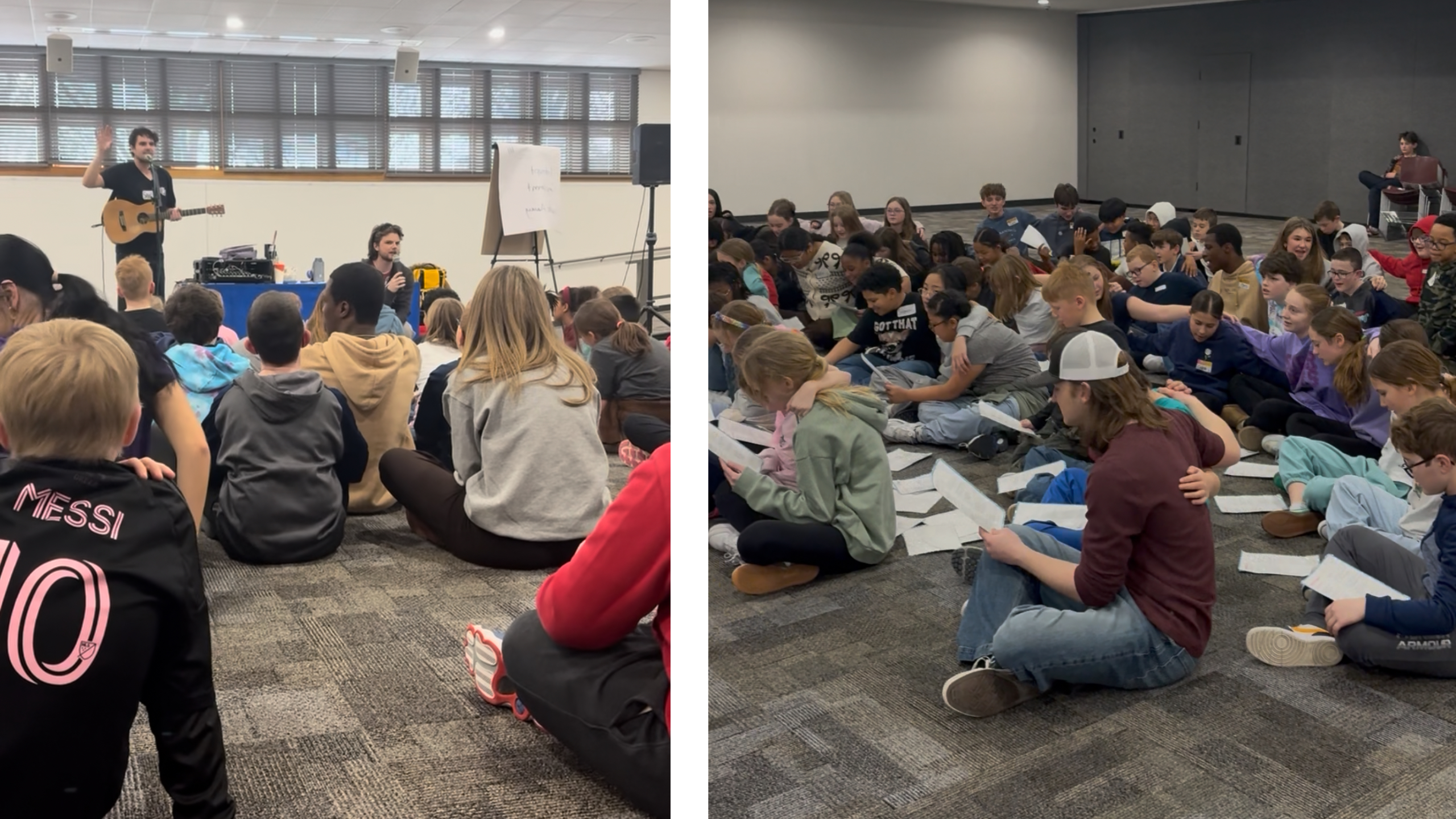 Speaker with guitar addressing a classroom audience of students seated on the carpet; a whiteboard and equipment visible on stage left.